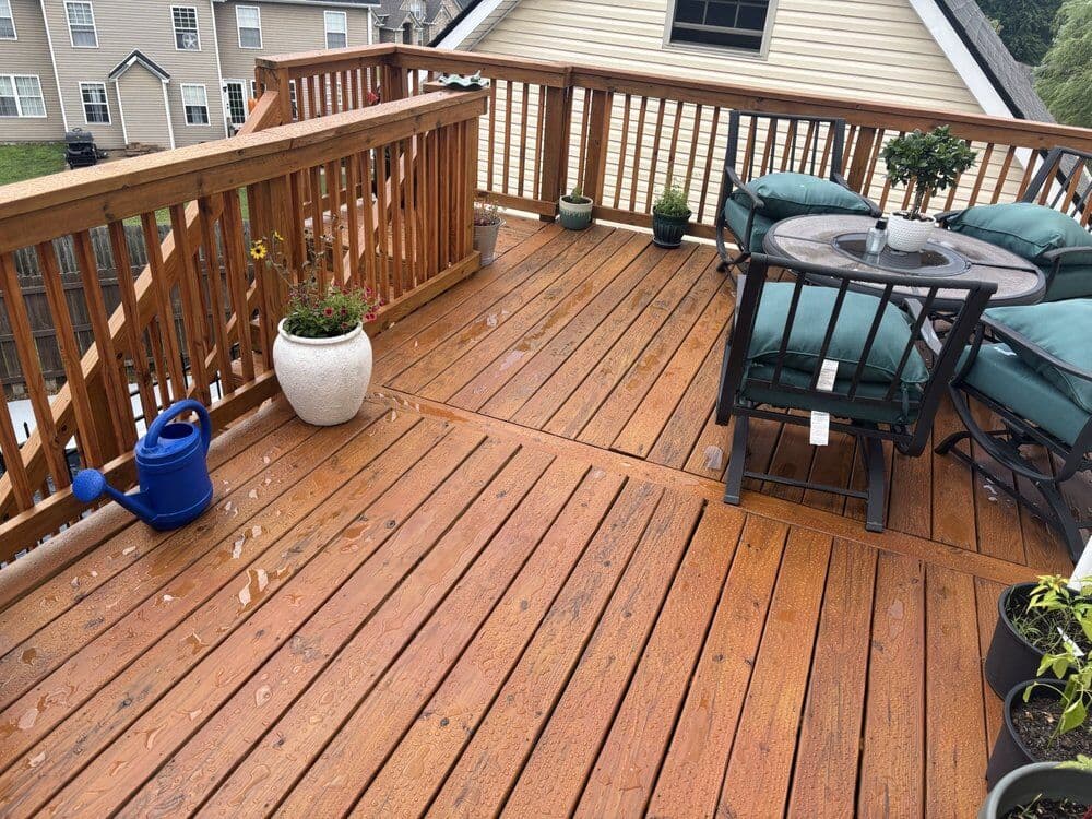 Freshly stained wood deck with railings and patio furniture